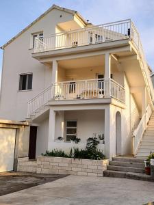 a white house with a balcony and stairs at Apartment Marko in Korčula