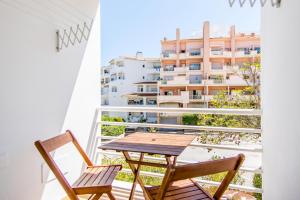 a table and chairs on a balcony with a building at #055 São José V by Home Holidays in Branqueira