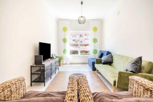 a living room with a couch and a tv at #055 São José V by Home Holidays in Branqueira