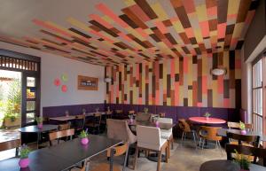 a restaurant with tables and chairs and a colorful ceiling at Hotel Casa Delina in Comitán