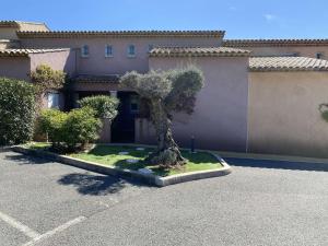 ein Baum auf einem Parkplatz vor einem Gebäude in der Unterkunft Maison Sainte-Maxime, 4 pièces, 6 personnes - FR-1-226-279 in Sainte-Maxime