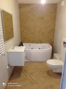 uma casa de banho com uma banheira branca e um WC. em Apartament z Jacuzzi i Sauna em Radom