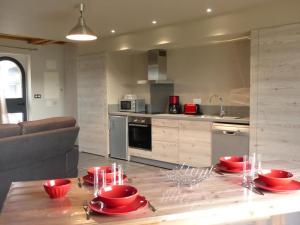 a kitchen with a table with red dishes on it at Gîte Chapeau, 3 pièces, 4 personnes - FR-1-489-79 in Chapeau