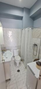 a white bathroom with a toilet and a sink at Sea & Sun cozy studio in Kremasti