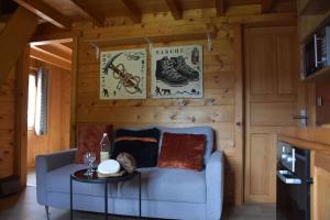 a living room with a blue couch and a table at Chalet L'Armoy in La Giettaz