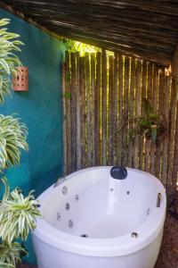 a bath tub in a bathroom with plants at Petit Quadrado no melhor lugar de Trancoso in Trancoso +17 photos