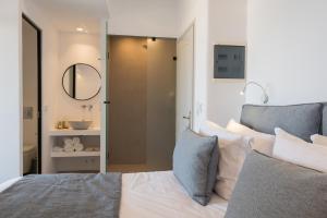 a bedroom with a bed with a mirror and a sink at Hotel Senia - Onar Hotels Collection in Naousa