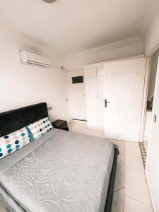 1 dormitorio con cama y puerta blanca en Hôtel champ élysée, en Saidia 