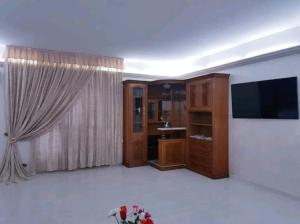 sala de estar con TV de pantalla plana y ventana grande en House with sea view/Casa con terrazzo vista mare, en Siderno Marina
