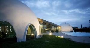 ein großes Gebäude mit einer Kuppel und einem Pool in der Unterkunft Naturhaus Luminus in Bad Aibling