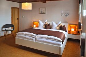 una camera da letto con un grande letto con due lampade e una sedia di Ferienwohnung "An den Kurwiesen" a Masserberg