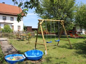 a swing set in a yard with two blue buckets at Ferienhaus Stockmeier in Otting +9 photos