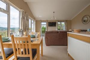 a kitchen and living room with a table and chairs at Tan Rallt Holiday Park & Spa in Abergele