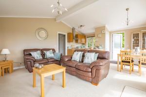 uma sala de estar com dois sofás de couro e uma mesa em Tan Rallt Holiday Park & Spa em Abergele