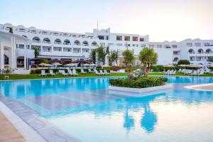 une piscine en face d'un grand bâtiment dans l'établissement Le Sultan, à Hammamet