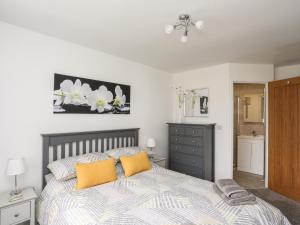 a bedroom with a bed with two yellow pillows at 31 Beach Road in Porthmadog