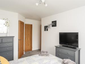 a bedroom with a bed and a tv on a dresser at 31 Beach Road in Porthmadog