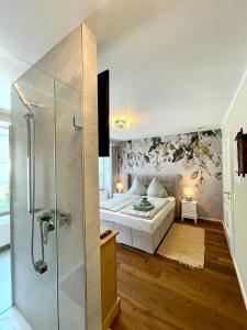 1 dormitorio con 1 cama y ducha acristalada en Moselblick Winningen Traumwohnung im „La Mosel“, en Winningen