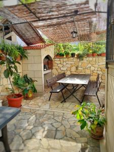 a patio with a table and chairs and a stone wall at Apartments Jakšić in Supetar