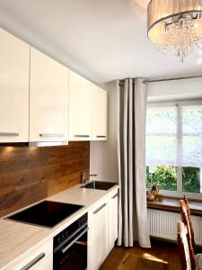 a kitchen with white cabinets and a sink and a window at Moselblick Winningen Traumwohnung im „La Mosel“ in Winningen