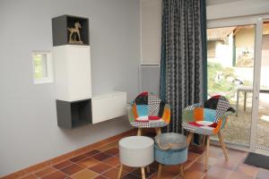 sala de estar con 2 sillas y ventana en Repos chez Margot en Fajoles