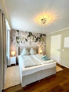 a bedroom with a bed and a chandelier at Moselblick Winningen Traumwohnung im „La Mosel“ in Winningen