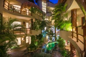 un edificio de apartamentos con piscina y plantas en Maya Villa Condo Hotel and Beachclub en Playa del Carmen