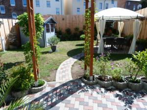 a garden with an umbrella and a patio at Ferienwohnung-Thale-Ritter in Thale
