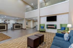 a lobby with a couch and chairs and a tv at Comfort Suites Columbus State University Area in Columbus