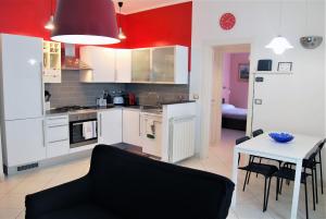 a kitchen with white cabinets and a table with chairs at Costa del Molo - Casa e Lavoro in Vado Ligure