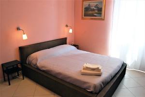 una camera da letto con un letto e un asciugamano sopra di Costa del Molo - Casa e Lavoro a Vado Ligure