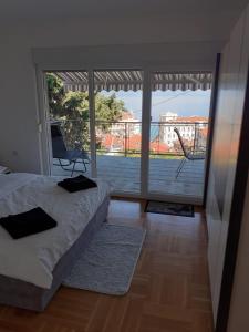 een slaapkamer met een bed en een groot raam bij Apartment Ella, Opatija in Opatija