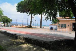 a street with trees and a building and the beach at Costa del Molo - Casa e Lavoro in Vado Ligure