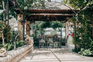 a patio with a table and chairs under a pergola at Apartman Dva mosta in Mostar