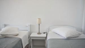 アクロティリにあるCaldera View Resort - Adults Onlyのベッドルーム1室(ベッド2台、テーブルの上にランプ付)