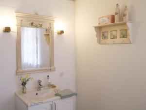 uma casa de banho com um lavatório e um espelho em Landlig idyl på Dommergården Bed and Coffee em Læsø