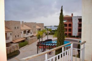 een balkon met uitzicht op een zwembad en gebouwen bij Victoria Gardens Luxury Apartment in Quarteira