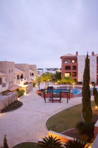 un patio con mesa de picnic y piscina en Victoria Gardens Luxury Apartment en Quarteira