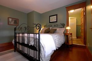 a bedroom with a bed with a white comforter at Phoenix House B&B in Stettler