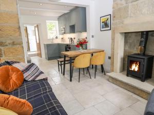 a living room with a fireplace and a table and chairs at Old Stone Cottage in Harrogate