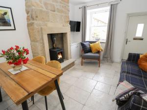 a living room with a table and a fireplace at Old Stone Cottage in Harrogate