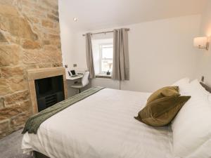 ein Schlafzimmer mit einem großen Bett und einem Kamin in der Unterkunft Old Stone Cottage in Harrogate