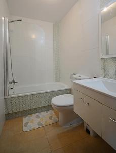 łazienka z toaletą, wanną i umywalką w obiekcie Apartamento con piscina próximo a Sanxenxo w mieście Sanxenxo