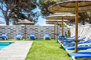 - un groupe de chaises longues et de parasols à côté de la piscine dans l'établissement Casa Torre De Meca 3 Shared Pool, à Los Caños de Meca