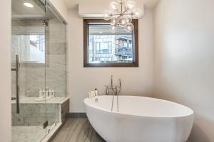 a white bathroom with a tub and a shower at Luxury Five Bedroom Private Home with stunning Park City views home in Park City +55 photos