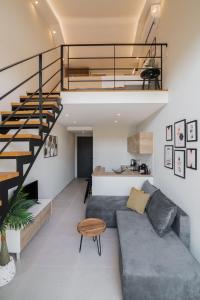 sala de estar con sofá y escalera en Bright & elegant loft suite in the city center, en Zakynthos