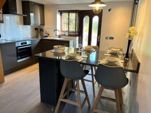 a kitchen with a table and two bar stools at Camellia Cottage in Camborne