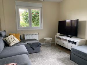 a living room with a couch and a flat screen tv at Casa Otilia - Rural - Camino de Santiago - Arzúa in Arzúa