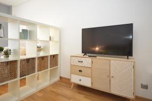 a living room with a flat screen tv on a entertainment center at Apartamento zona exclusiva con garaje gratis y Netflix in Vigo