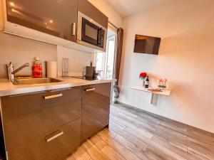 uma pequena cozinha com um lavatório e um balcão em Les Studios du Pêcheur - Hypercentre - Clim - City Trip em Ajaccio